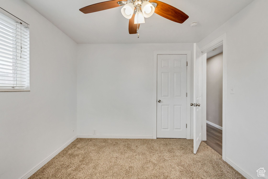 Unfurnished bedroom featuring ceiling fan and light carpet