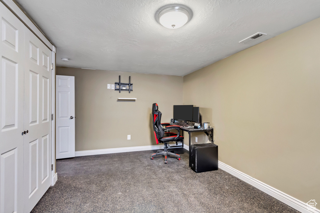 Home office featuring dark colored carpet