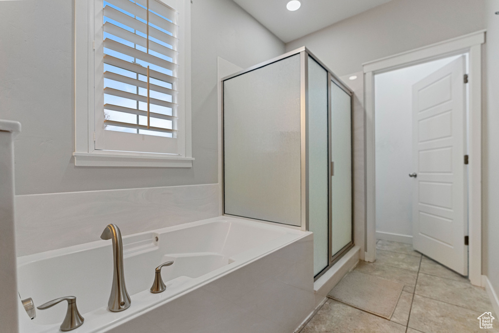 Bathroom featuring separate shower and tub and tile floors