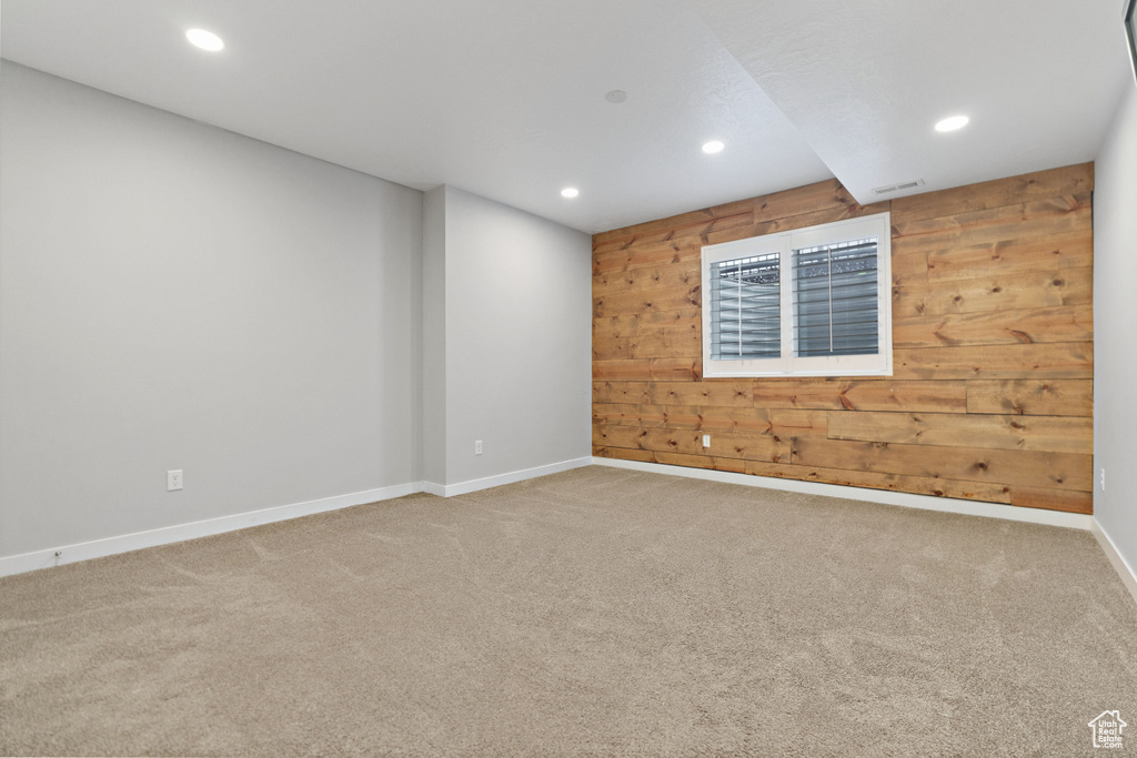 Spare room with wooden walls and light carpet