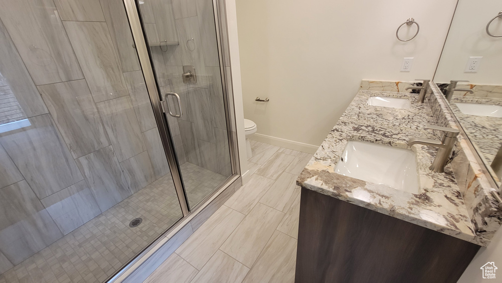 Bathroom with tile flooring, dual vanity, walk in shower, and toilet