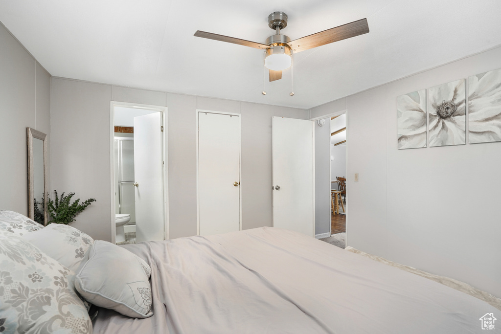 Bedroom featuring hardwood / wood-style flooring, ceiling fan, and ensuite bathroom