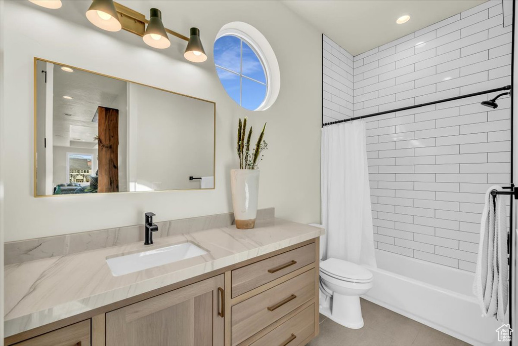 Full bathroom with vanity, toilet, tile floors, and shower / bathtub combination with curtain