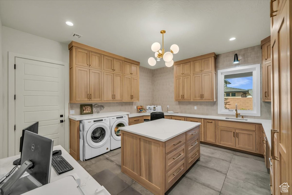 Interior space with washer and clothes dryer, hanging light fixtures, a center island, a chandelier, and light tile flooring