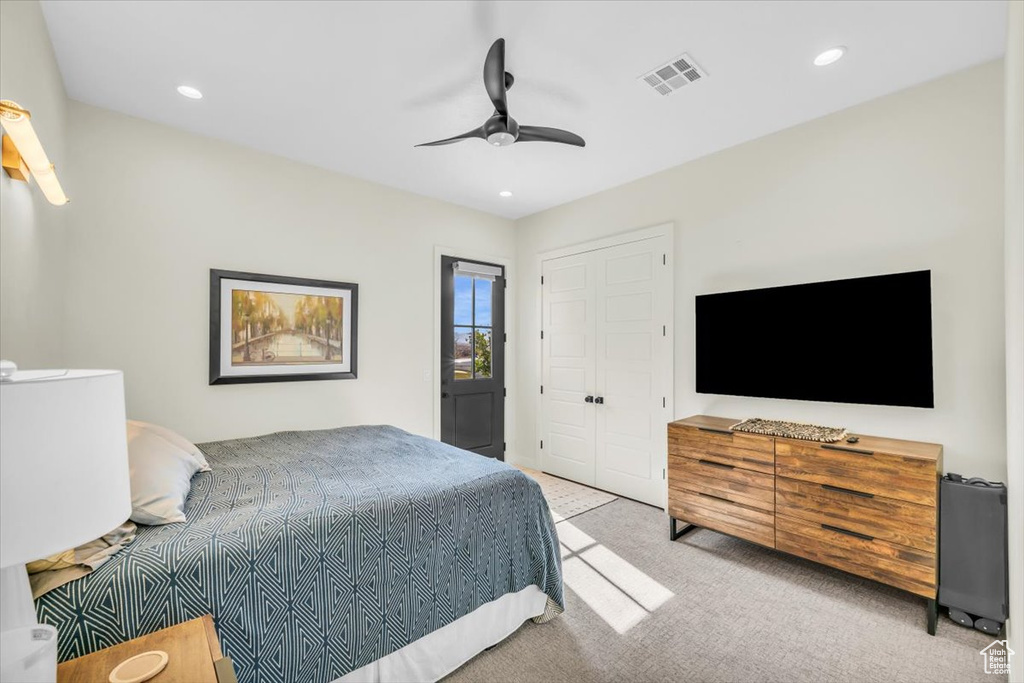 Bedroom featuring ceiling fan, light colored carpet, and a closet