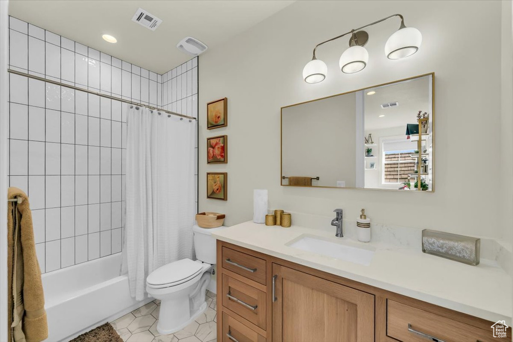 Full bathroom featuring toilet, tile flooring, oversized vanity, and shower / bath combo with shower curtain