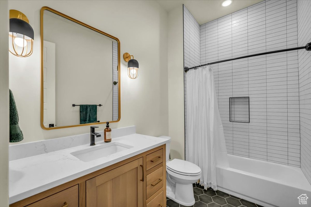 Full bathroom with vanity, toilet, tile floors, and shower / tub combo