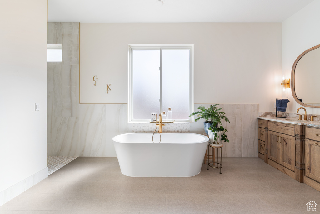 Bathroom featuring vanity, tiled shower, and tile flooring