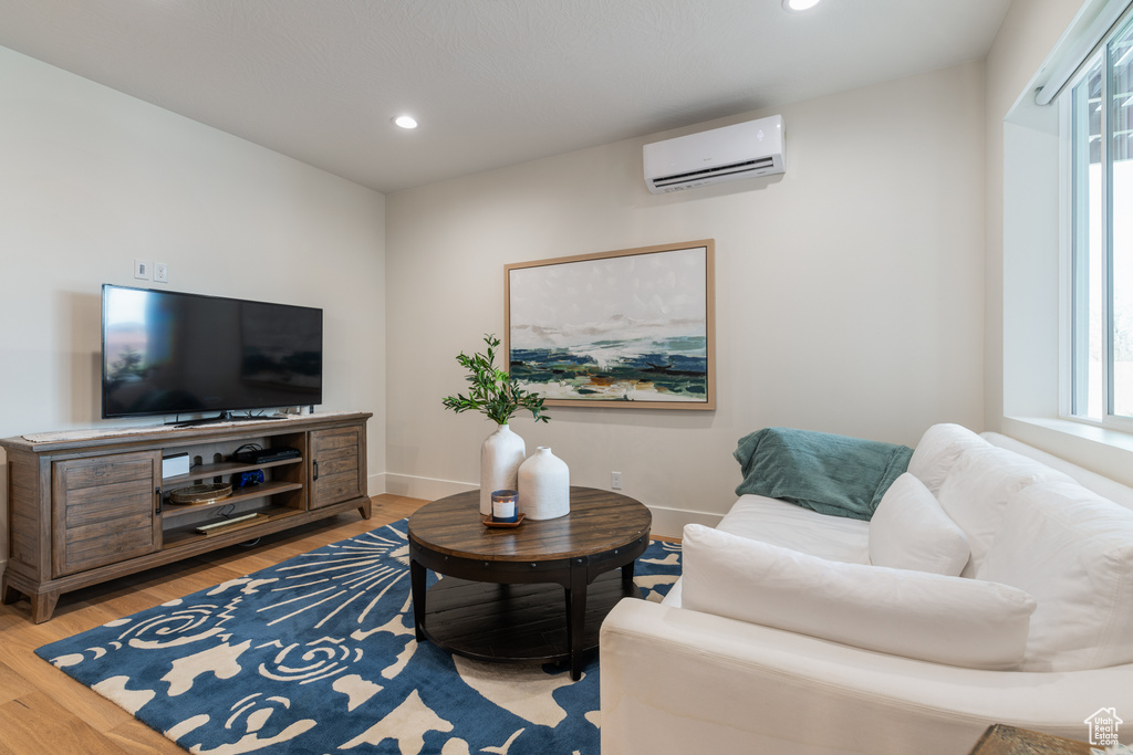 Living room featuring light hardwood / wood-style floors and a wall mounted AC