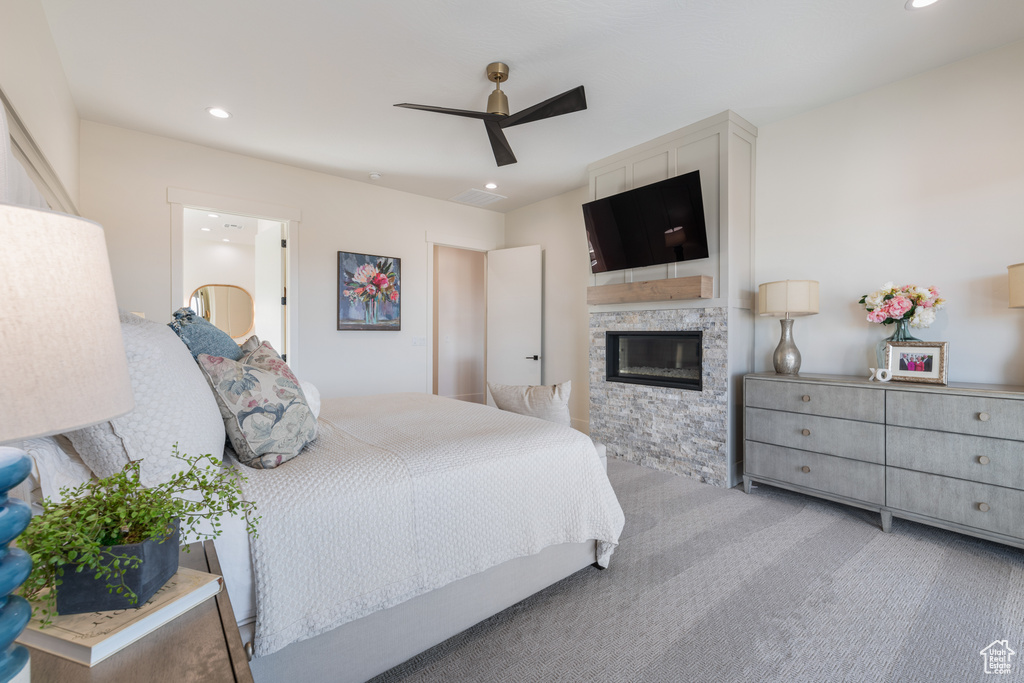Bedroom with a fireplace, ceiling fan, and light carpet