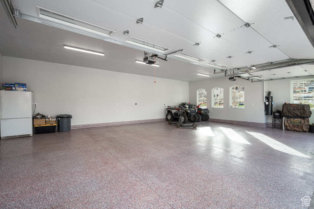 Garage with white refrigerator and water heater