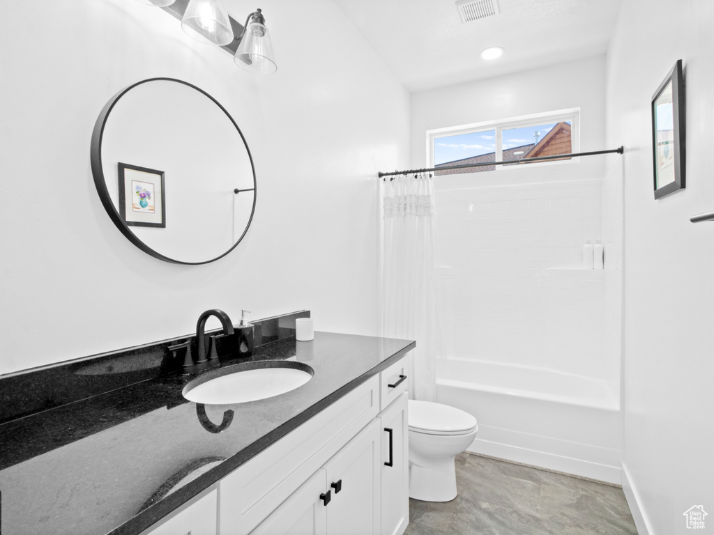Full bathroom featuring vanity, toilet, tile floors, and shower / tub combo