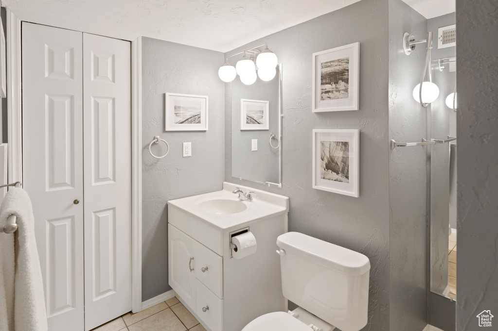 Bathroom featuring large vanity, tile flooring, and toilet