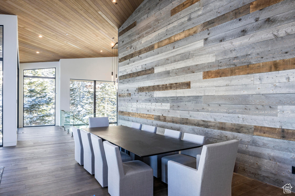 Unfurnished dining area featuring wood walls, high vaulted ceiling, dark hardwood / wood-style floors, and wood ceiling
