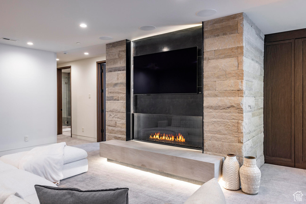 Carpeted living room with a fireplace and tile walls
