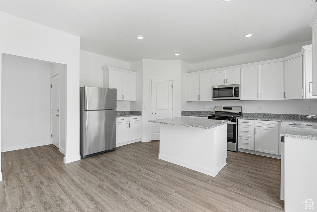 Kitchen featuring white cabinetry, stainless steel appliances, and light wood-type flooring