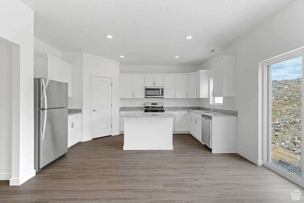 Kitchen featuring white cabinets, a kitchen island, and stainless steel appliances