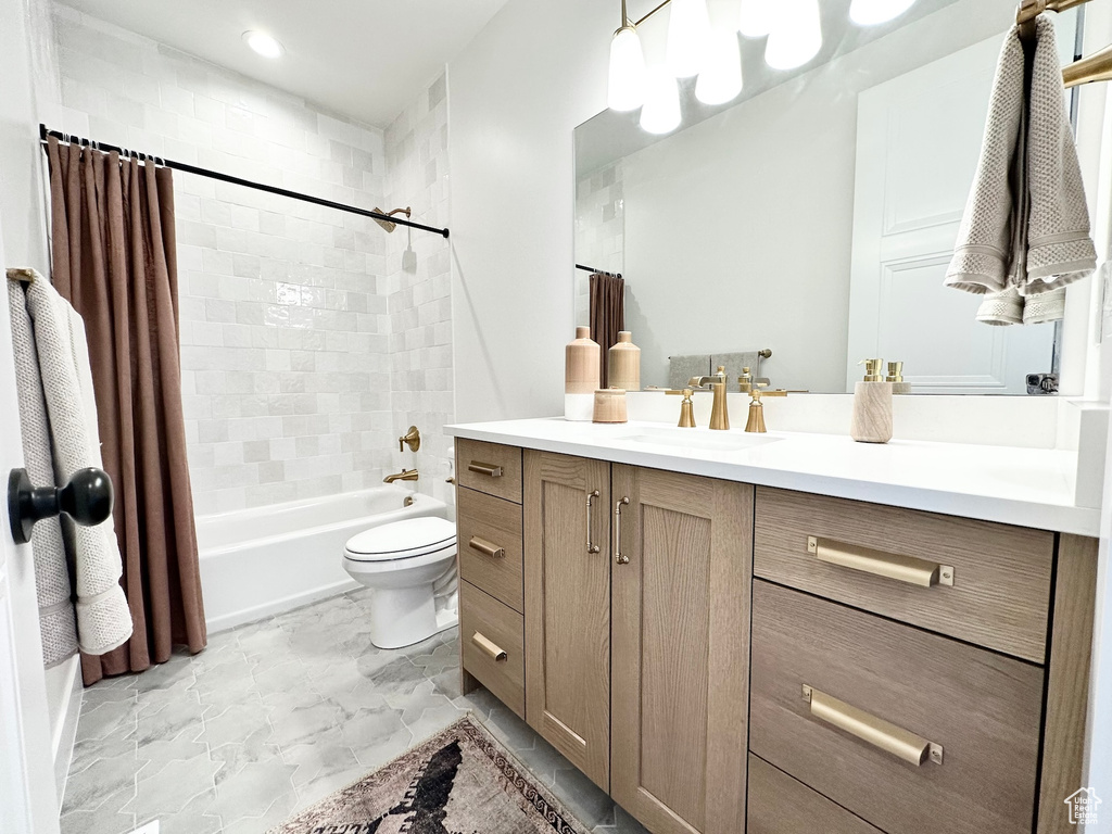 Full bathroom featuring tile flooring, toilet, vanity, and shower / tub combo