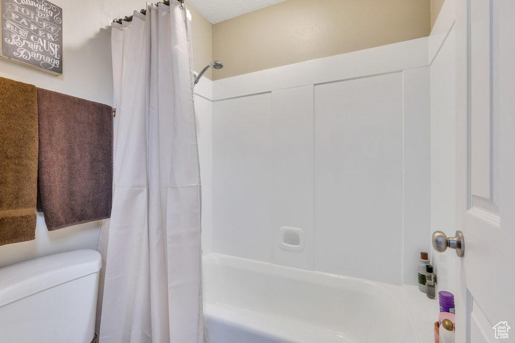 Bathroom featuring toilet and shower / tub combo
