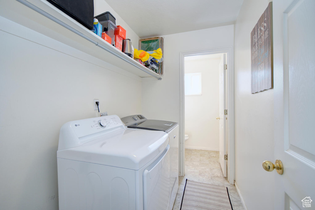 Laundry room with light tile floors and washer and dryer