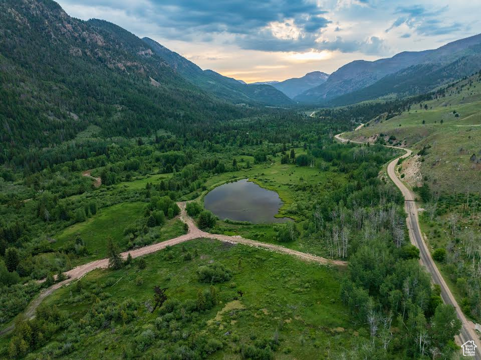 Aerial view at dusk featuring a water and mountain view