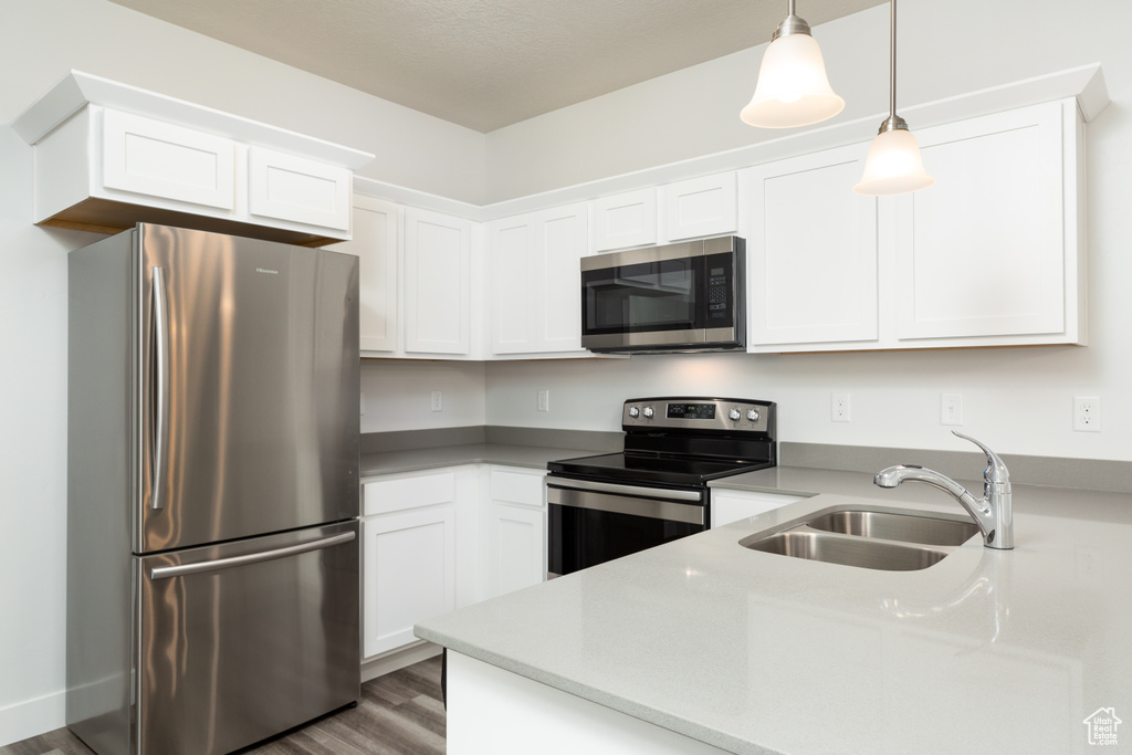Kitchen featuring white cabinetry, sink, and stainless steel appliances