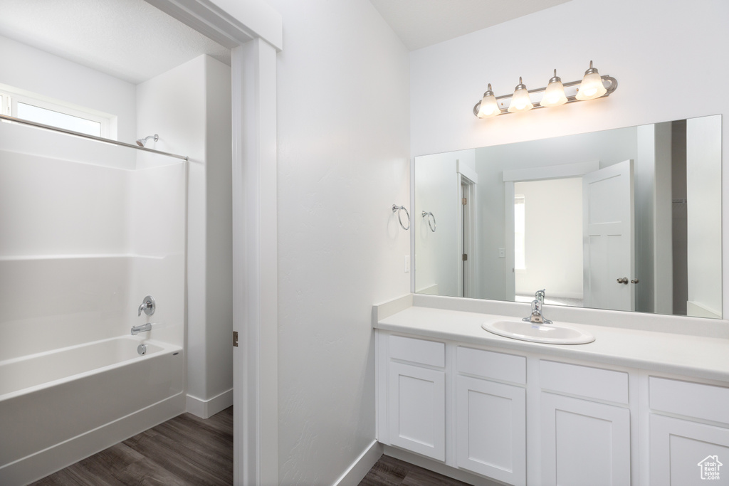 Bathroom featuring vanity, washtub / shower combination, and hardwood / wood-style floors