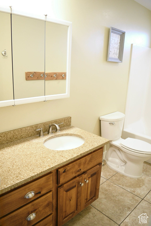 Full bathroom with vanity, toilet, washtub / shower combination, and tile flooring