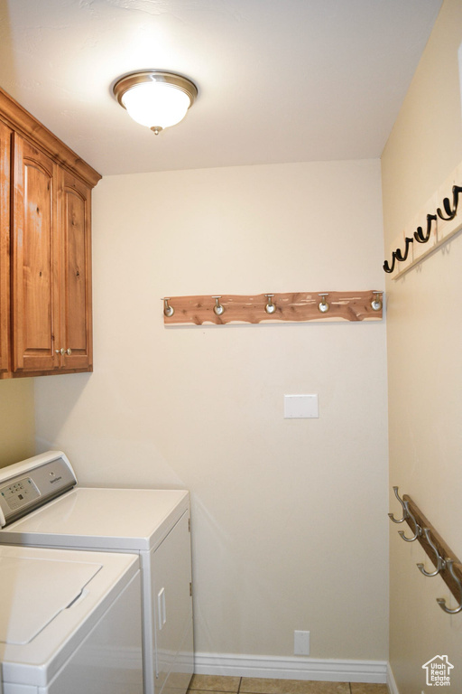 Laundry room featuring cabinets, separate washer and dryer, and light tile floors
