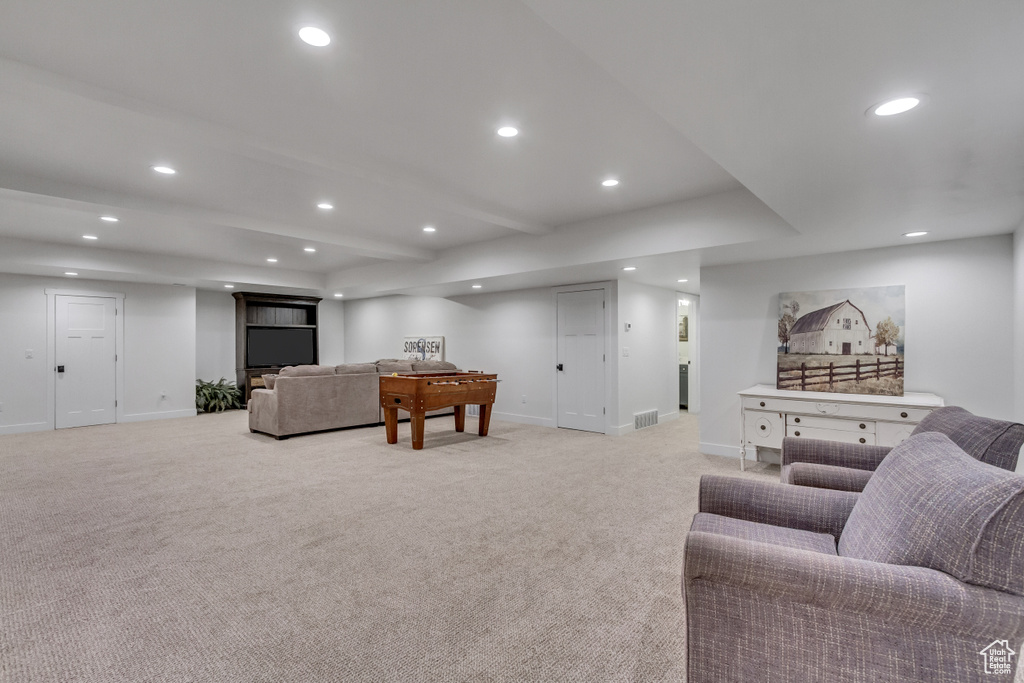 Carpeted living room featuring beamed ceiling