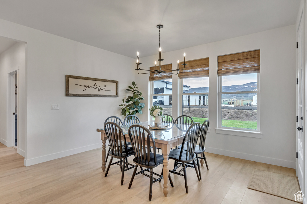 Dining area featuring a chandelier, light hardwood / wood-style floors, and a mountain view