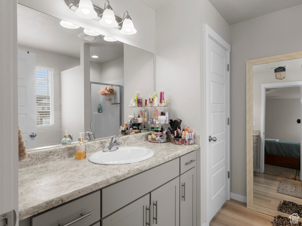 Bathroom featuring hardwood / wood-style floors and vanity with extensive cabinet space
