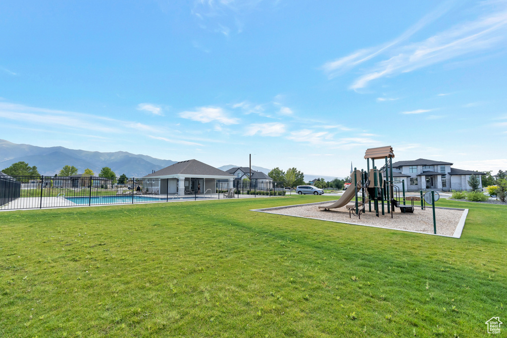 View of yard featuring a mountain view, a fenced in pool, and a playground
