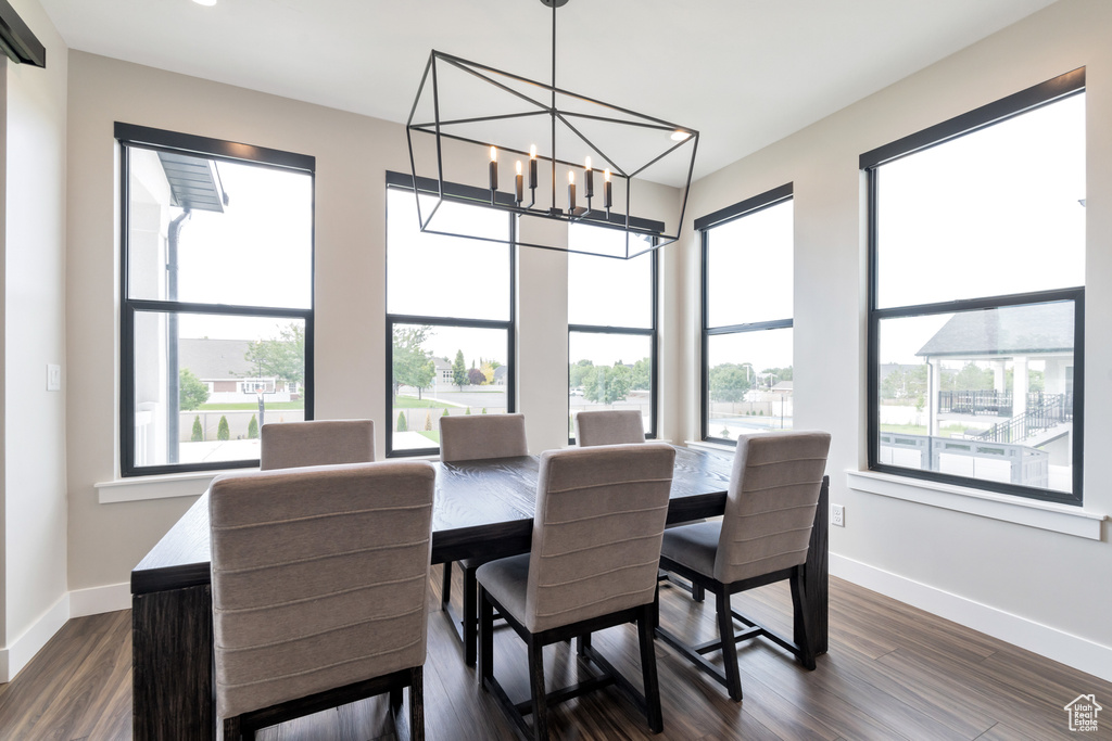 Dining room featuring dark hardwood / wood-style floors and an inviting chandelier