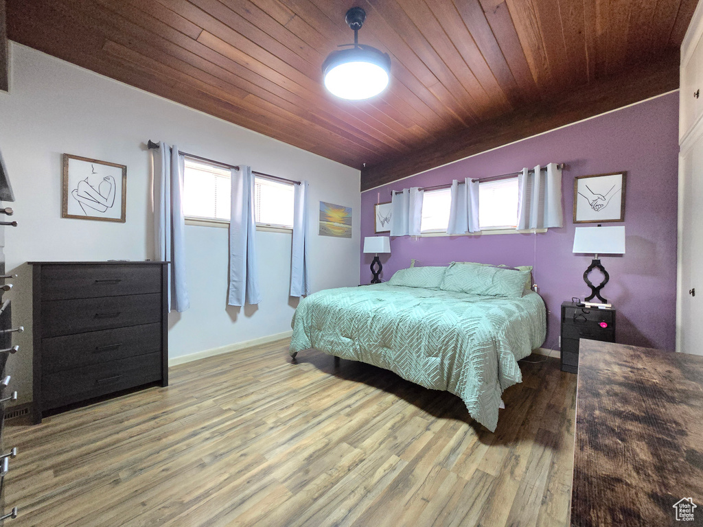 Bedroom with wood ceiling, multiple windows, and wood-type flooring