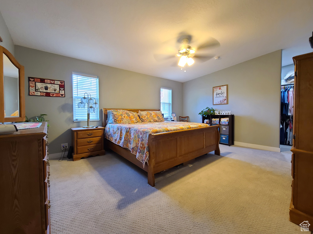 Carpeted bedroom with multiple windows, a closet, and ceiling fan