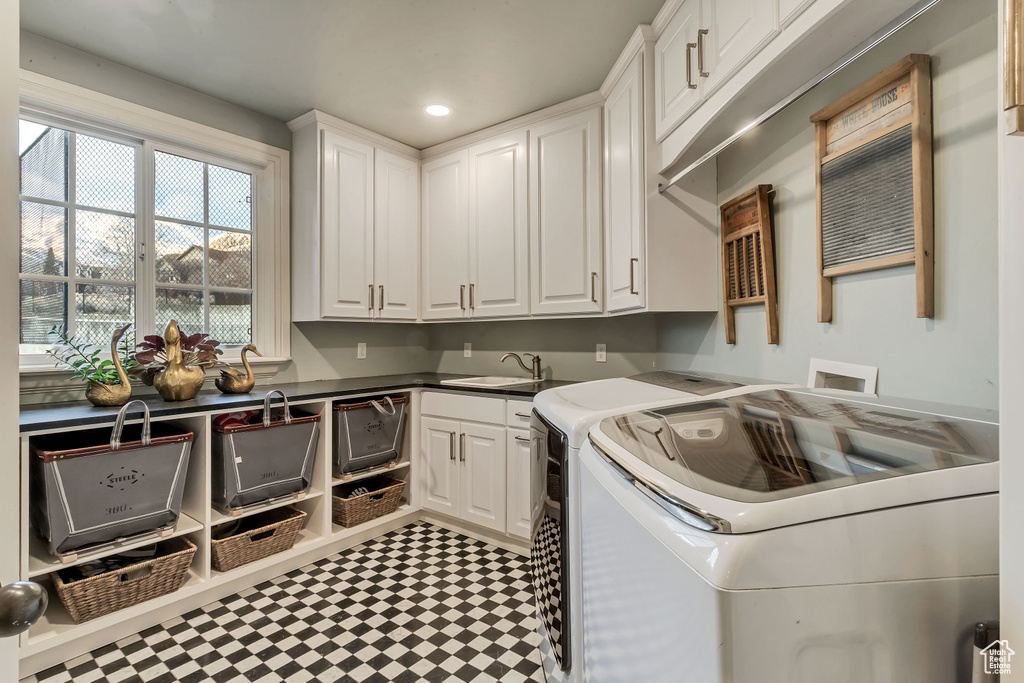 Laundry room featuring cabinets, sink, washing machine and dryer, and tile floors