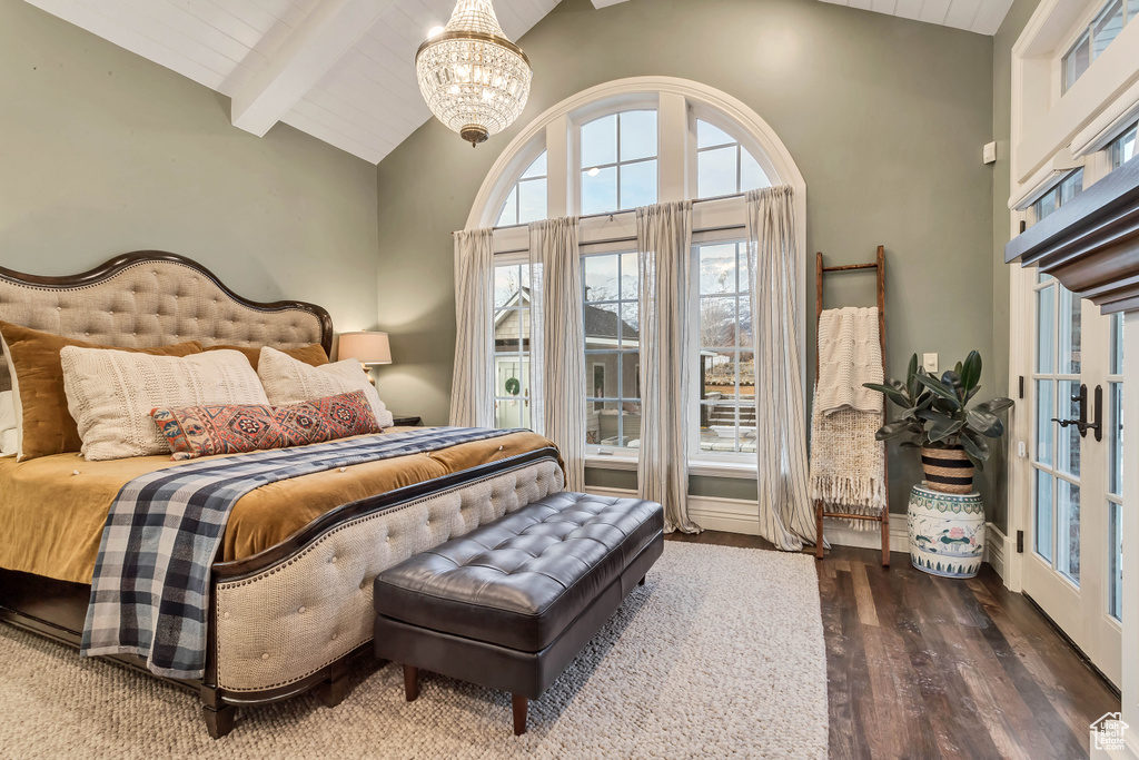 Bedroom with dark hardwood / wood-style flooring, french doors, a chandelier, high vaulted ceiling, and beam ceiling