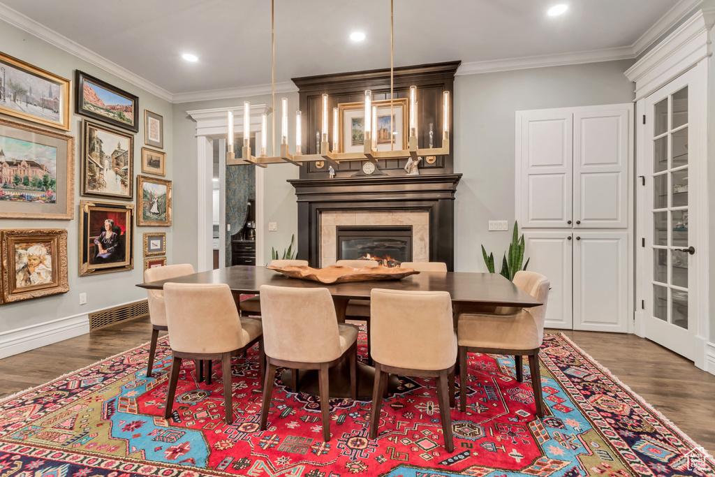 Dining space with dark wood-type flooring and crown molding