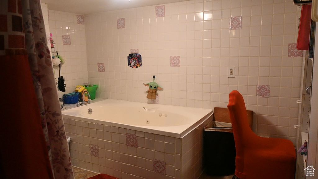 Bathroom featuring tile walls and tiled bath