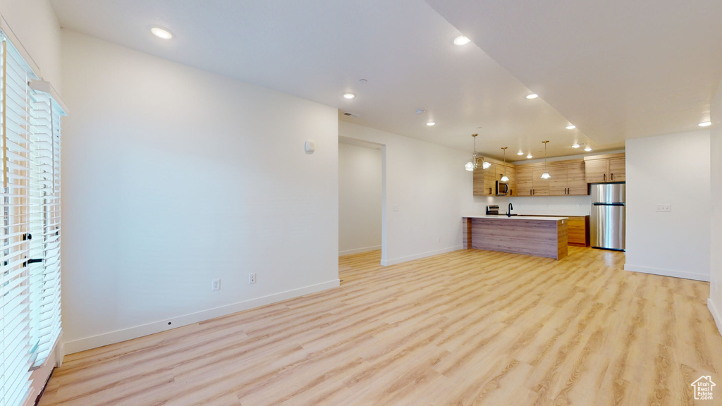Unfurnished living room featuring light hardwood / wood-style flooring and sink