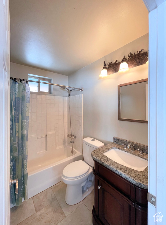 Full bathroom with vanity, shower / bath combo, tile flooring, and toilet