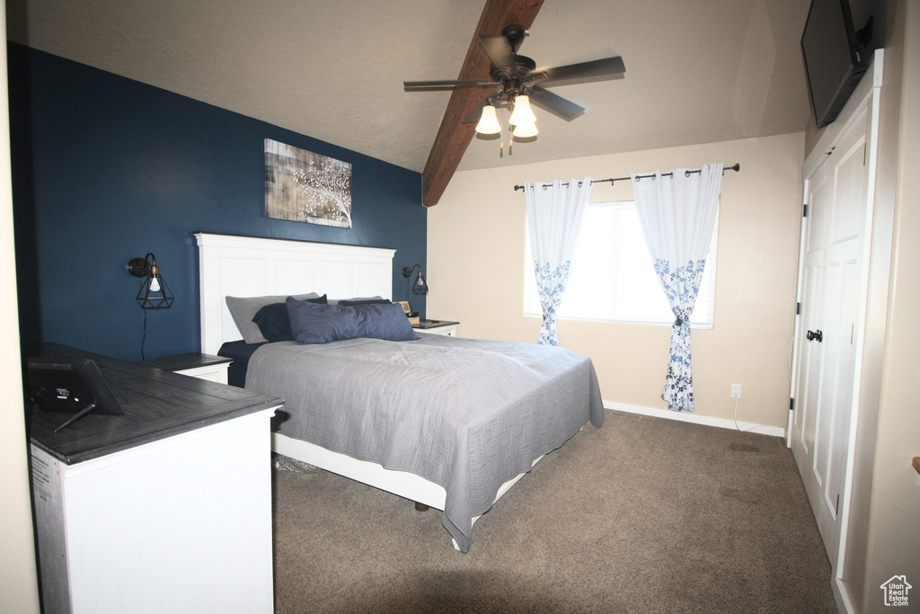Bedroom with ceiling fan, beam ceiling, and dark carpet