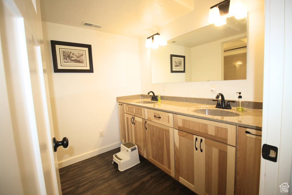 Bathroom with hardwood / wood-style floors and dual vanity