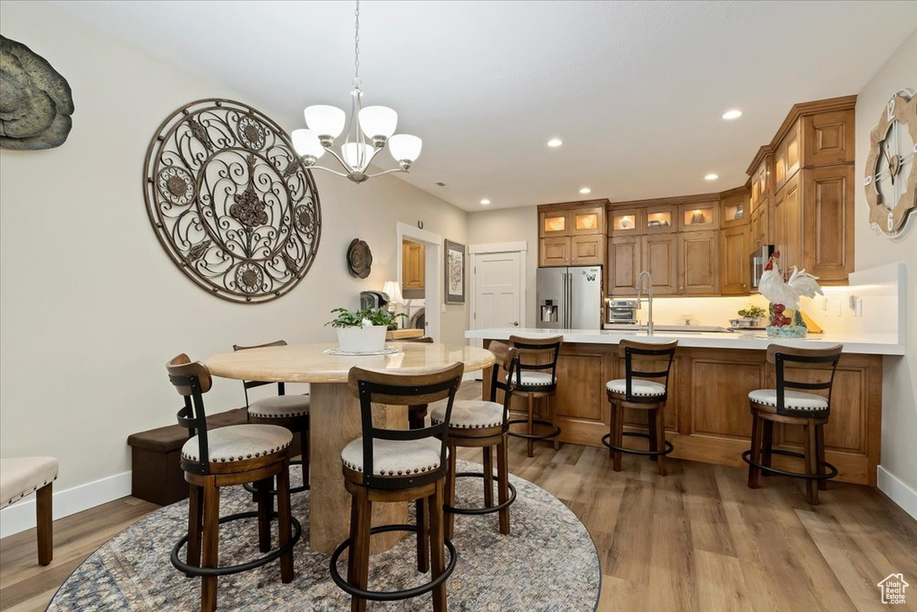 Dining space featuring an inviting chandelier and hardwood / wood-style flooring