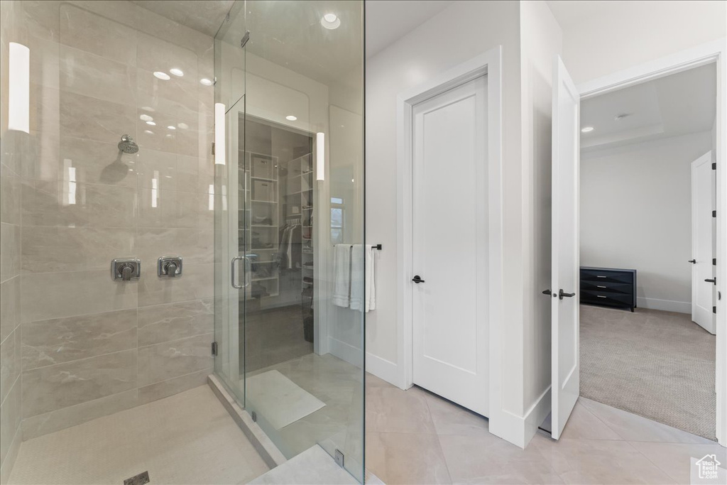 Bathroom with a shower with shower door and tile floors