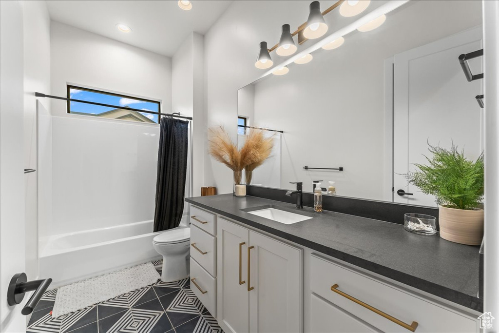 Full bathroom featuring vanity, shower / bath combo, toilet, and tile flooring