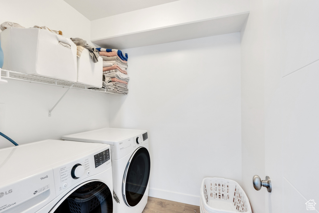Laundry room with light wood-type flooring and washing machine and dryer