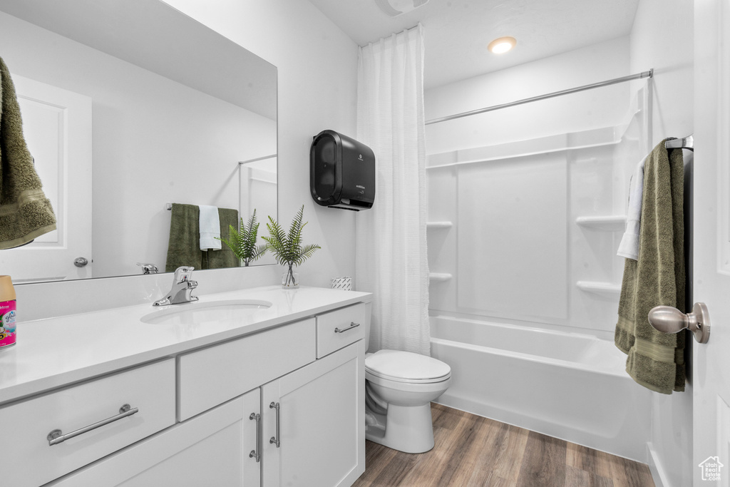 Full bathroom featuring vanity, toilet, shower / tub combo, and wood-type flooring