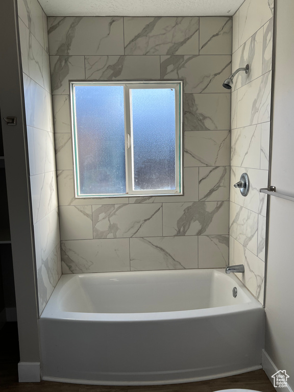 Bathroom featuring hardwood / wood-style floors and tiled shower / bath combo